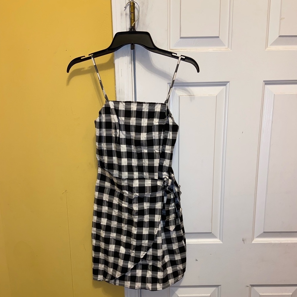 Mid thigh length, body con, black & white checkered wrap dress; zip-up back